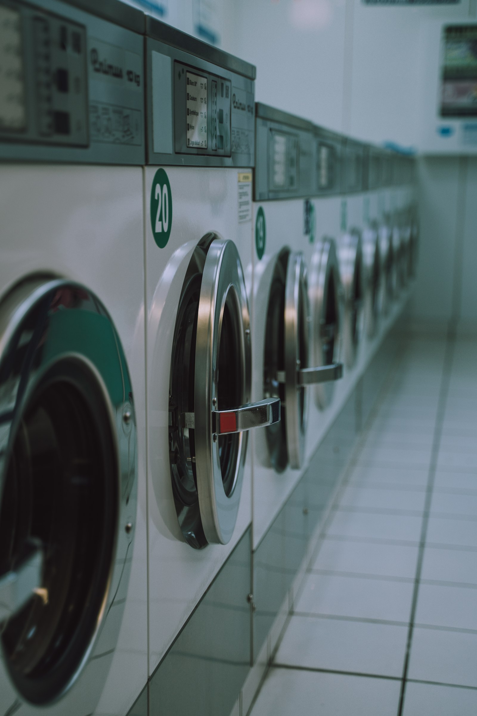 Row of commercial front-load laundry machines in an industrial facility
